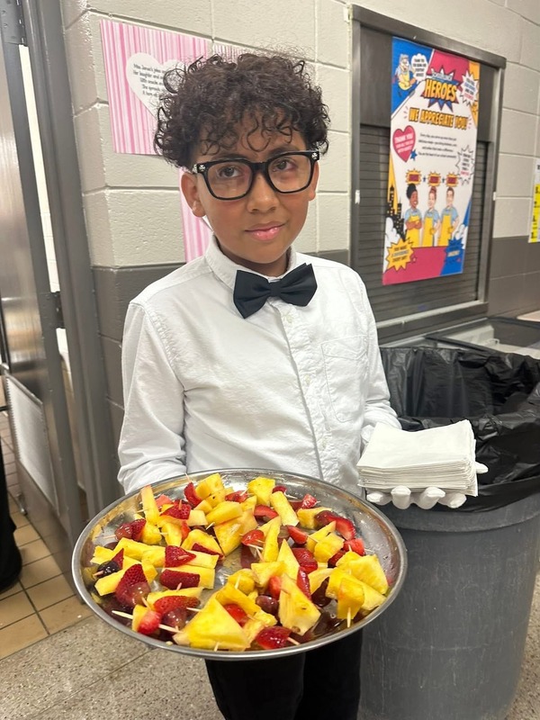 5th grader, Julian, serving hors d'oeuvres, in the cafeteria.