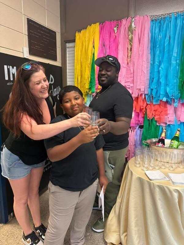3rd grader, Oliver, and his family saying "cheers" with sparking juice.