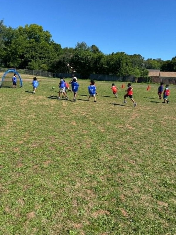 A group of students playing soccer on the field.