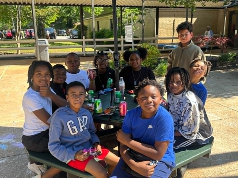 5th graders sitting in the courtyard enjoying their snack.