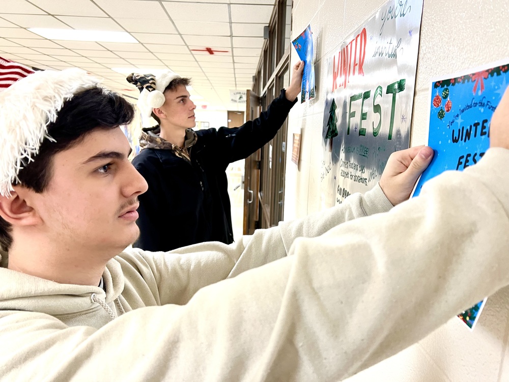 Lilianna Roth/The Hive Adan Pecina and Mason Douglas post Winter Fest flyers in the hallway by the library at Huntsville High School. Journalism and yearbook students are excited about the first Winter Fest, which takes place at HHS on Saturday from noon to 5 p.m. Santa Claus will be there all day to take pictures with kids. Also, there will be a fun photo booth, games and holiday movies.