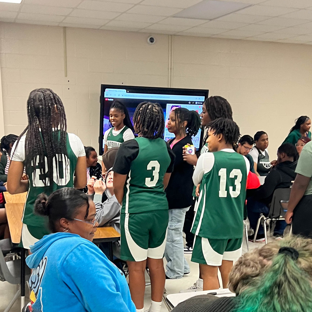 lady Hornet basket players playing with a student