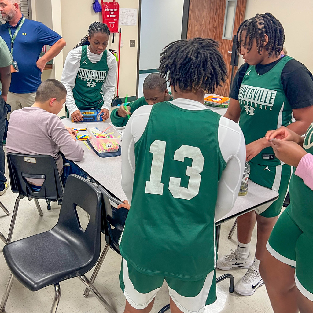lady Hornet basket player playing with a student