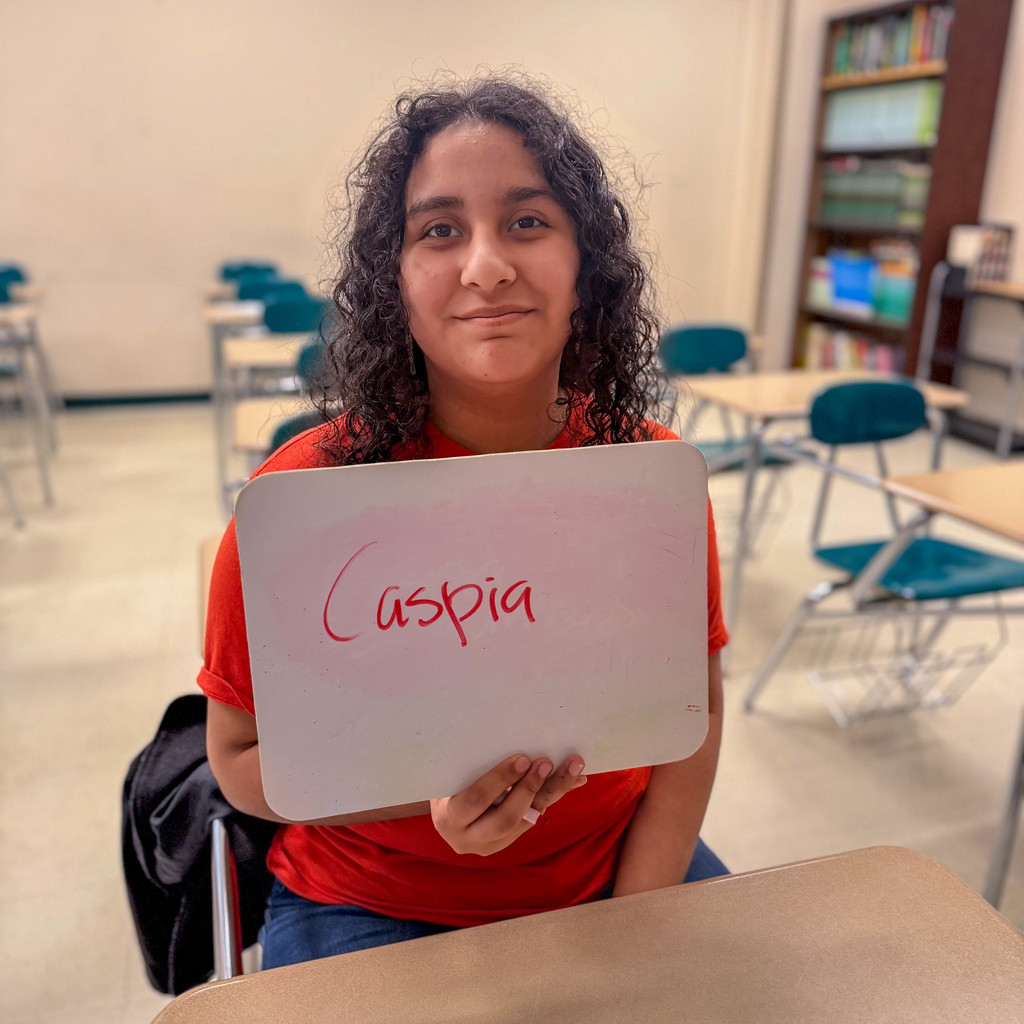 Student holds up sign that says caspia