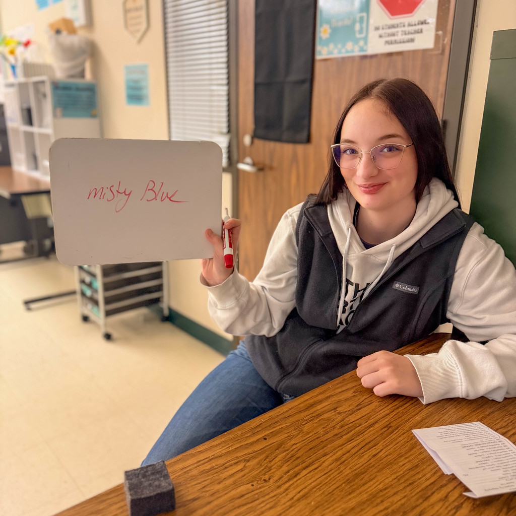 Student holds up sign that says Misty Blue