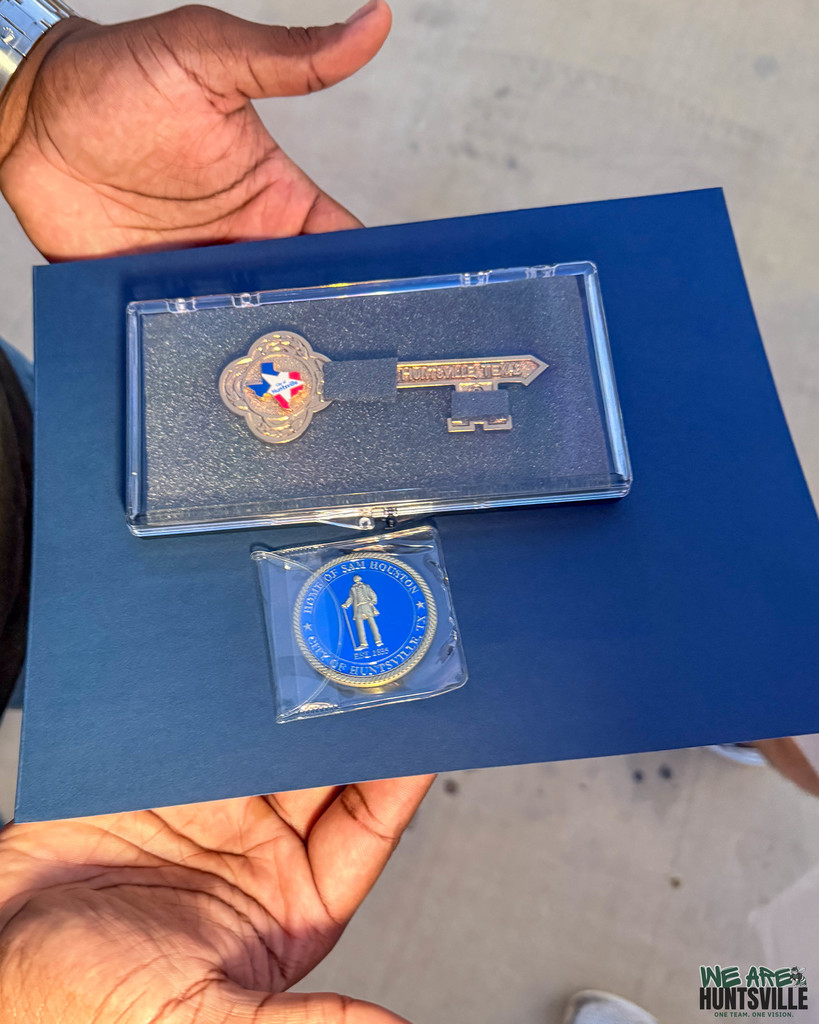 T'vondre Sweat Getting the Key to the City- close up of key and coin