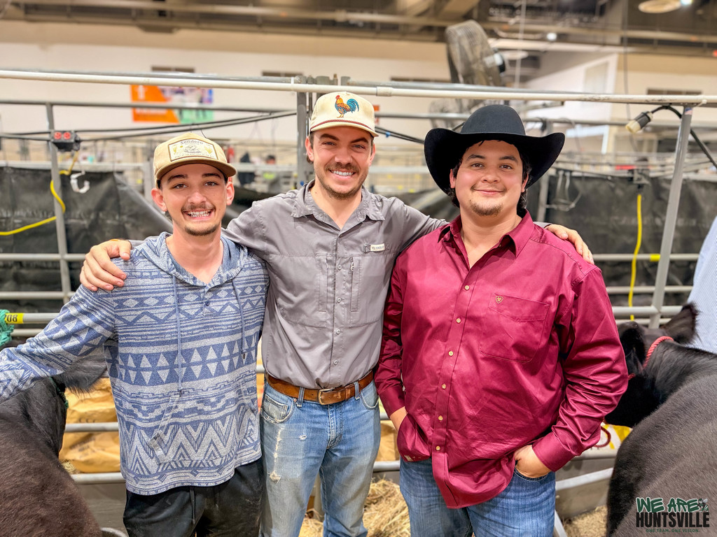 A teacher with his two students at the livestock area of the HSLR