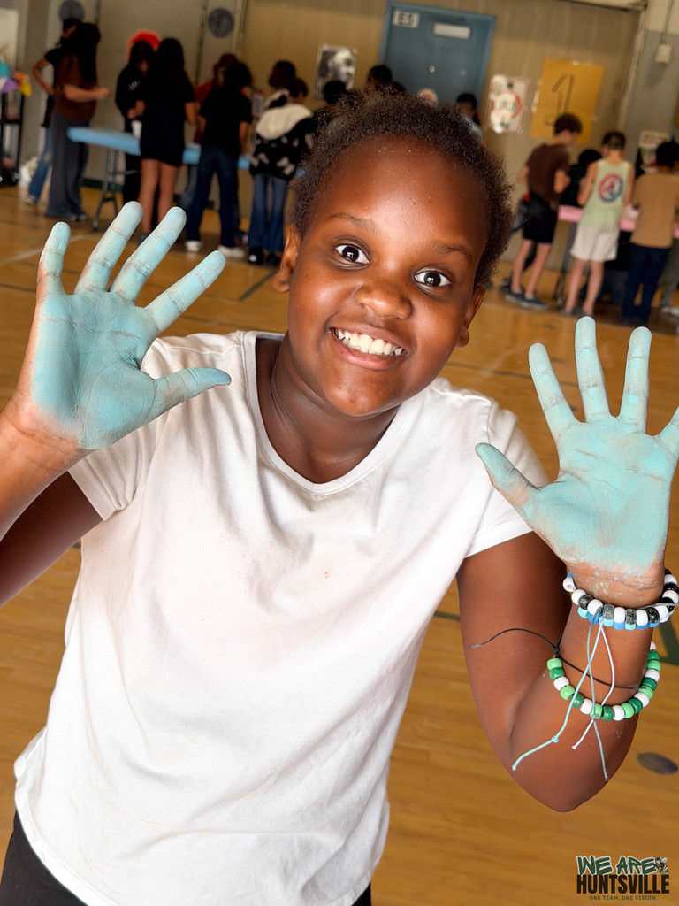 Girl showing her hands with chalk on therm