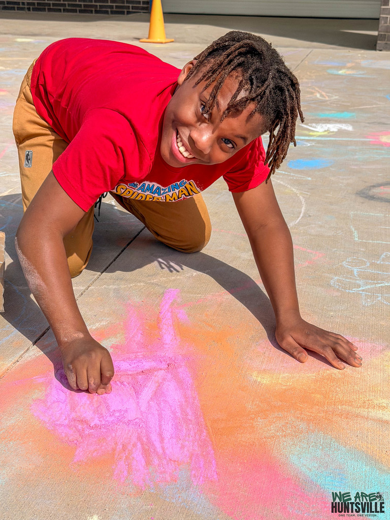 boy looking up from chalk drawing