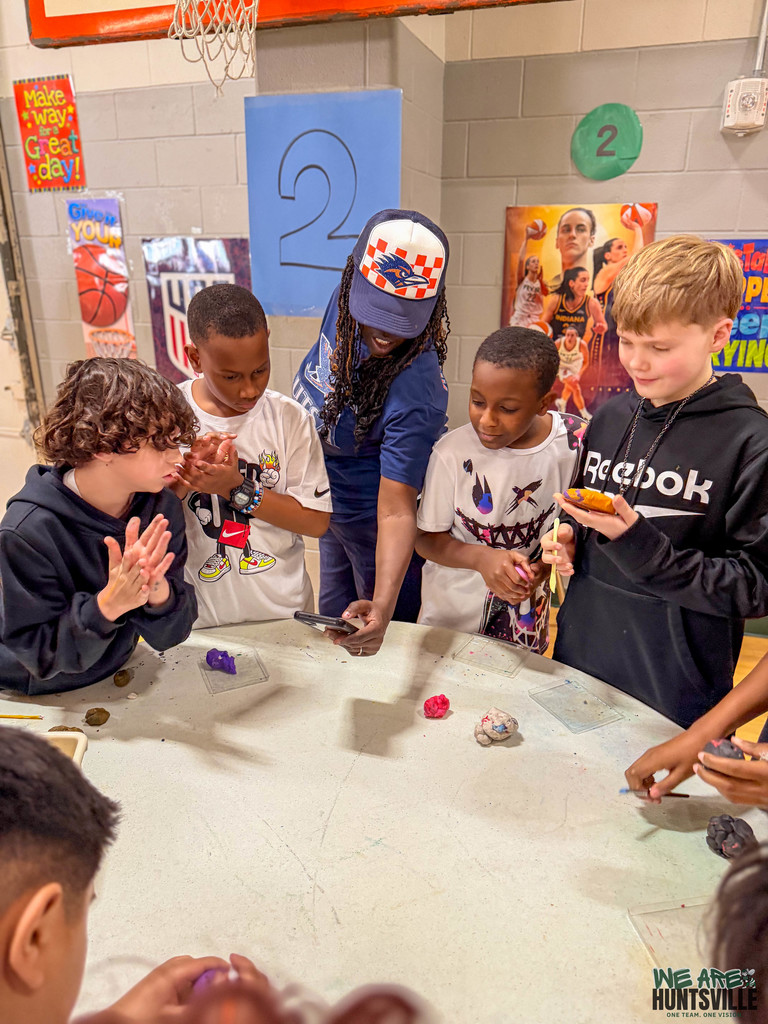 teacher with boys working with clay