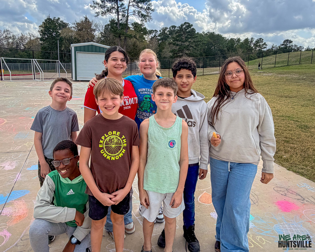 Group of kids taking a break from doing a chalk drawing