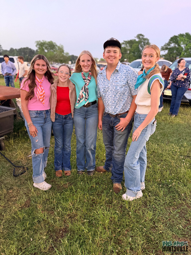 four highschoolers pose outside of barn