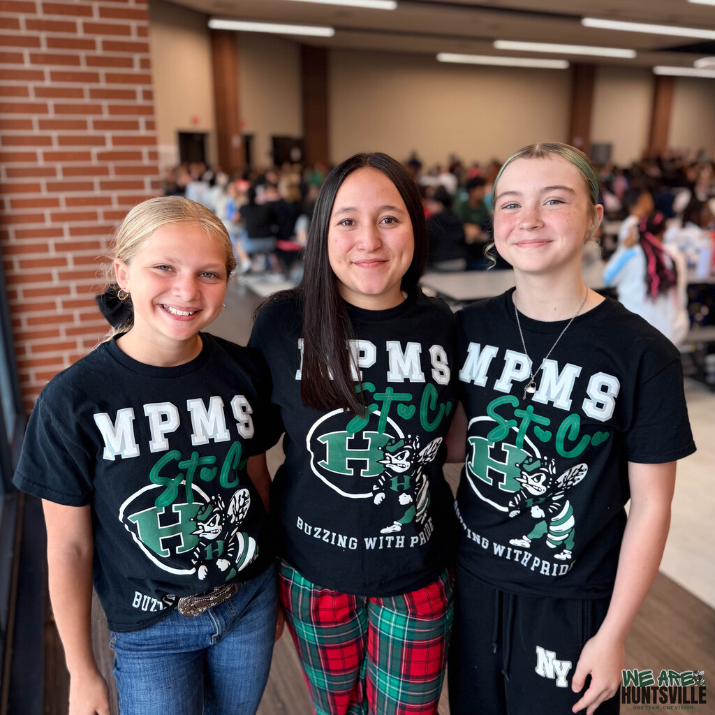 three middle schoolers pose with thie student council shirts