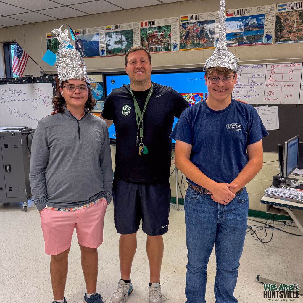 Two high school students with their teacher-- they are wearing aluminium foil hats