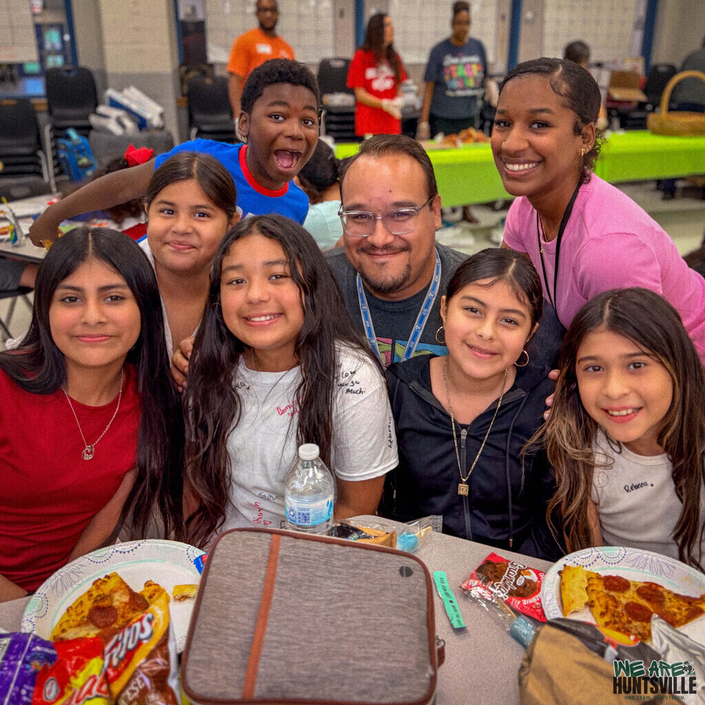 Big group of elementary school students surround their teacher for a group photo
