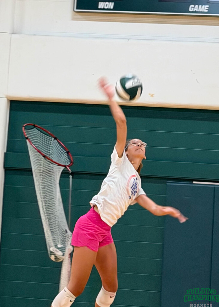 student hits volleyball hard