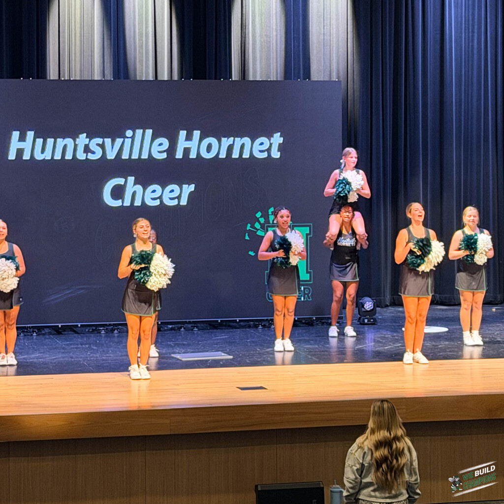 Cheer coach watches her teams practice performance
