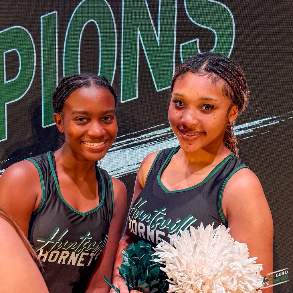 Two cheer team members smiling