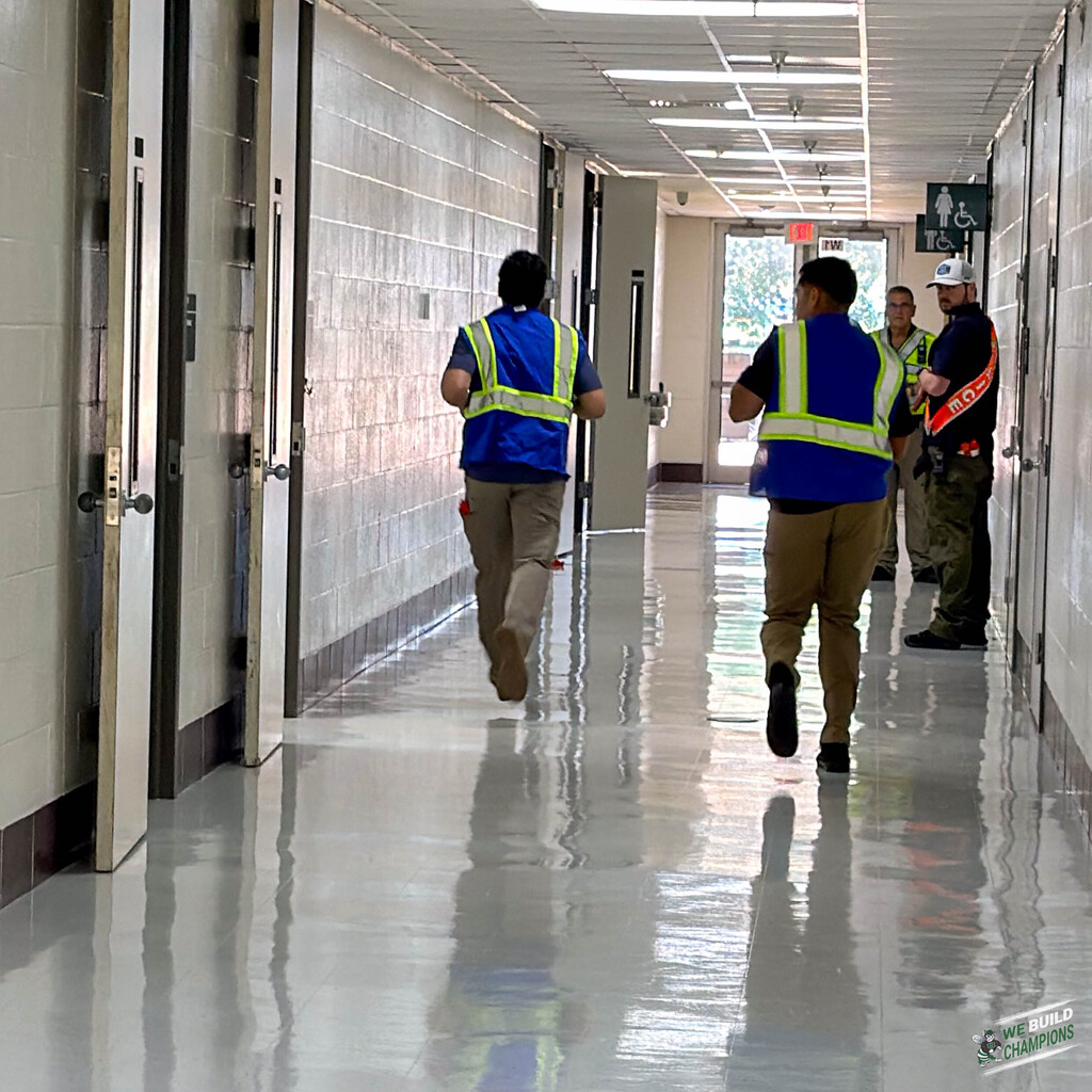Trainers move quickly down a hallway