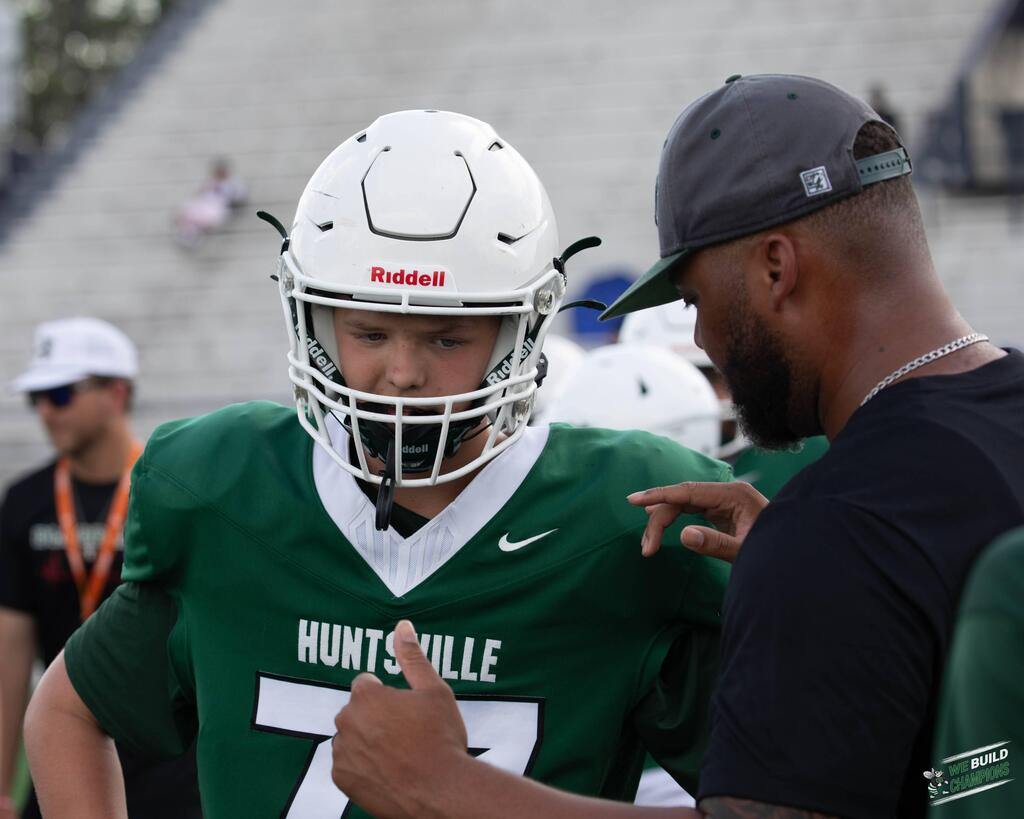 Coach explaining a play to a player, player concentrating