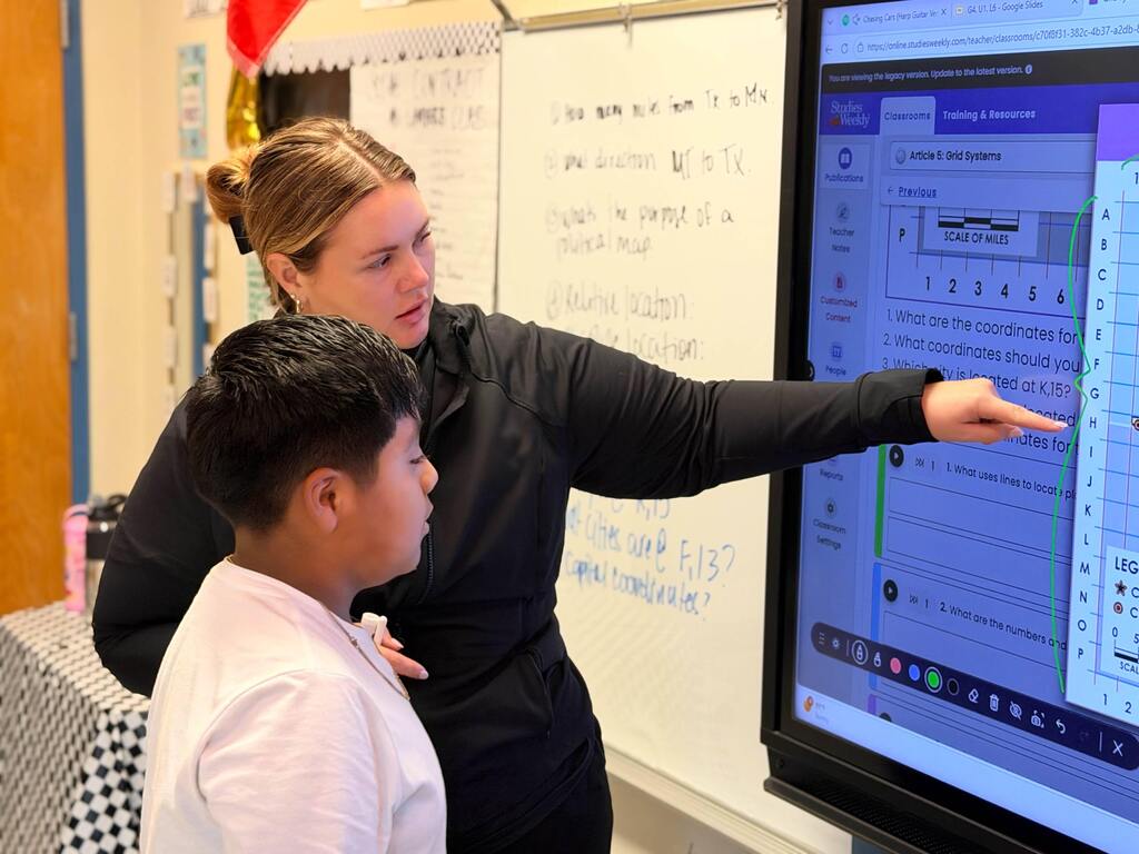 Teacher points out coordinates to student on Promethean board