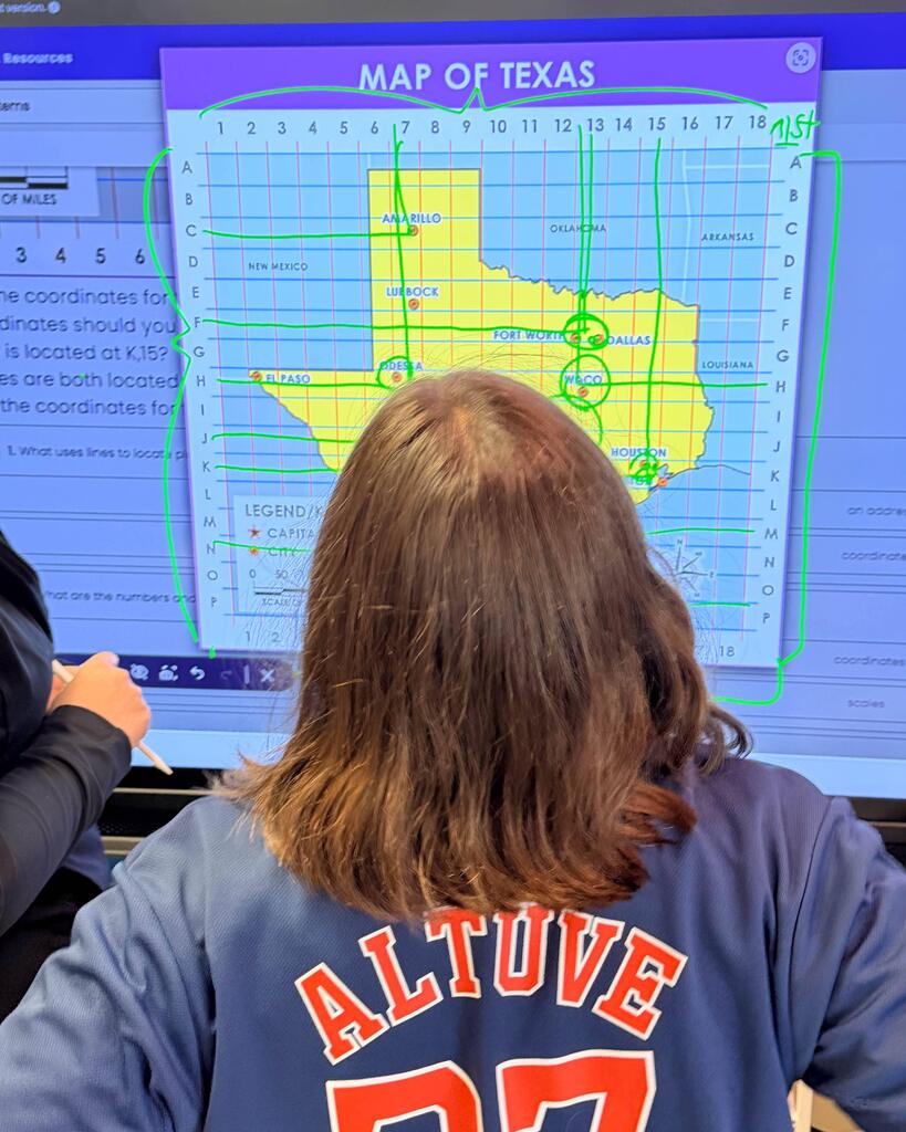 student with back to camera- map of texas on promethean board
