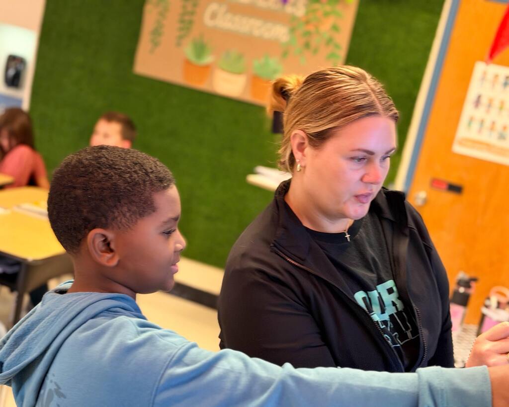 student points out coordinates to teacher on Promethean board