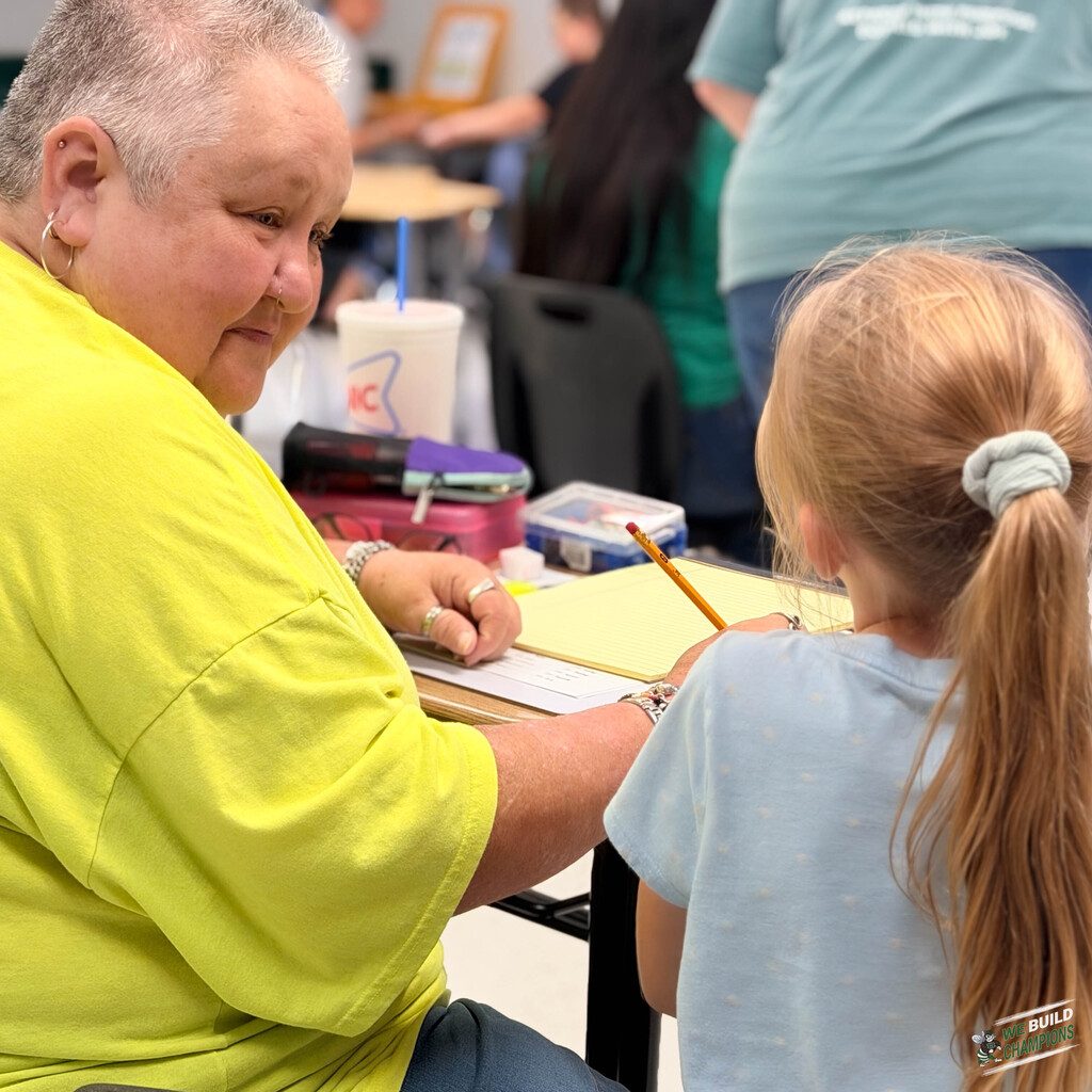 Volunteer looking intently at student