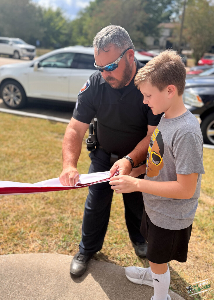 SRO helping student straighten flag