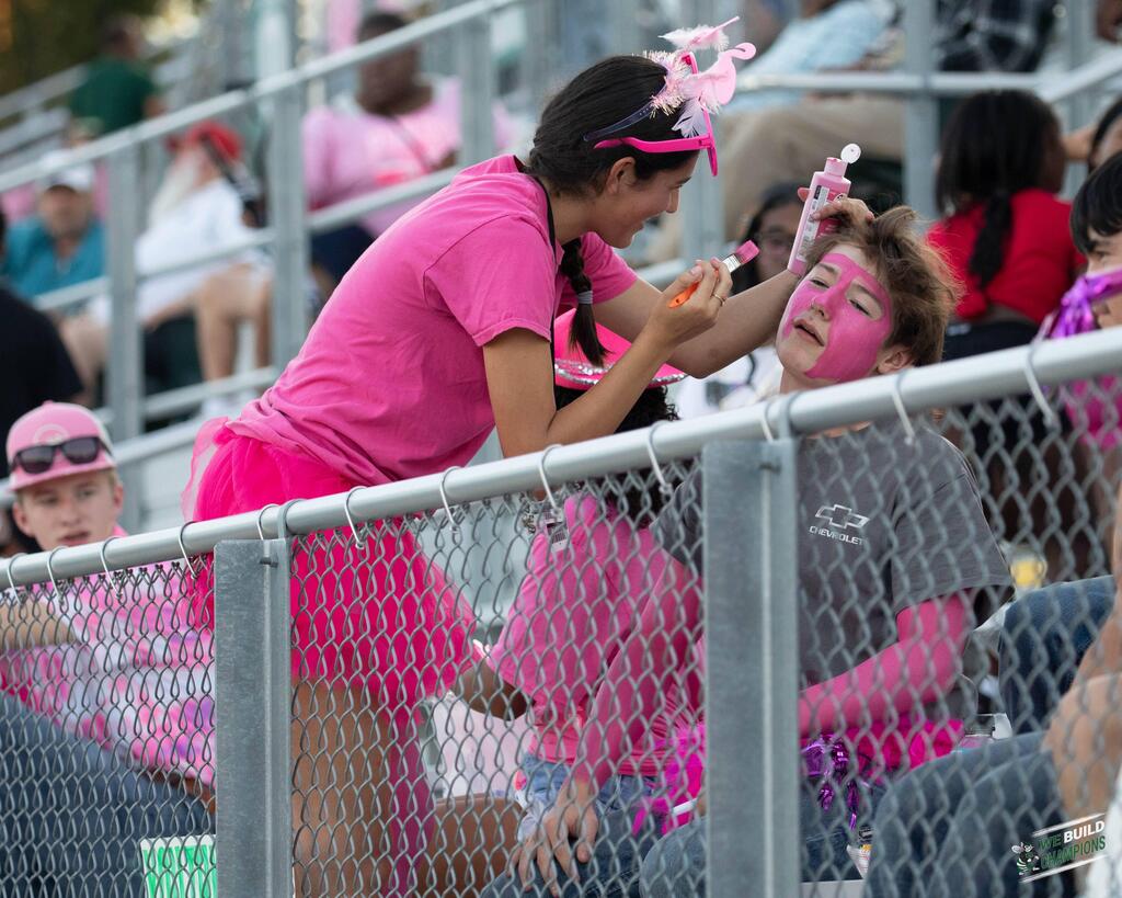 Applying pink paint on friend