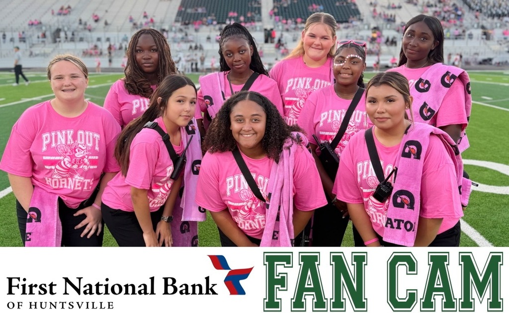 These are the athletic trainers posing for a photo on the field pregame dressed in pinnk