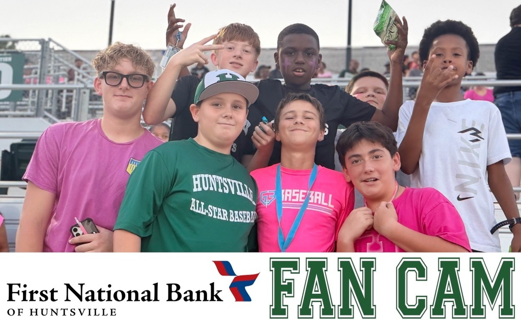 Middle school students in the stands posing in pink