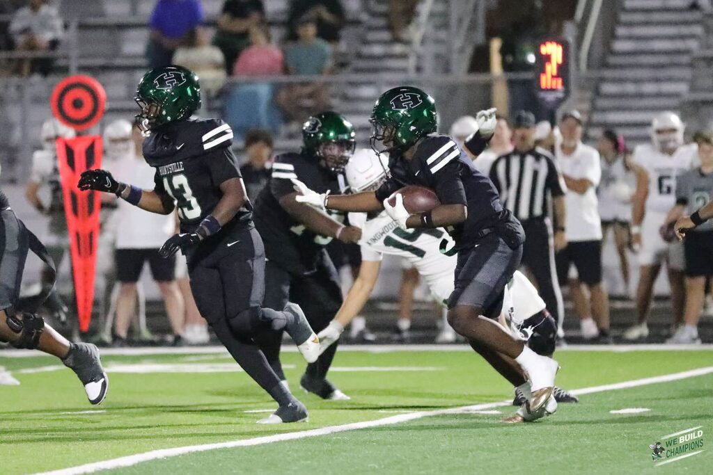 hornet football players blocking for a runner