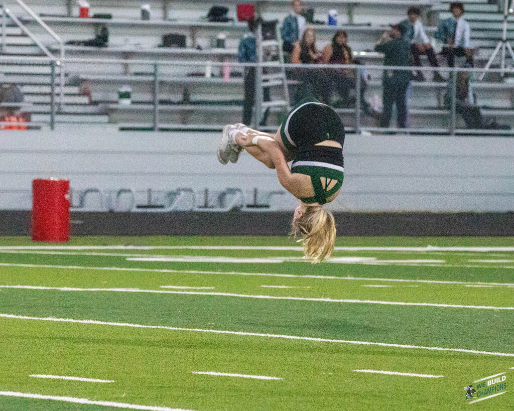 Cheer team member upside down, mid flip
