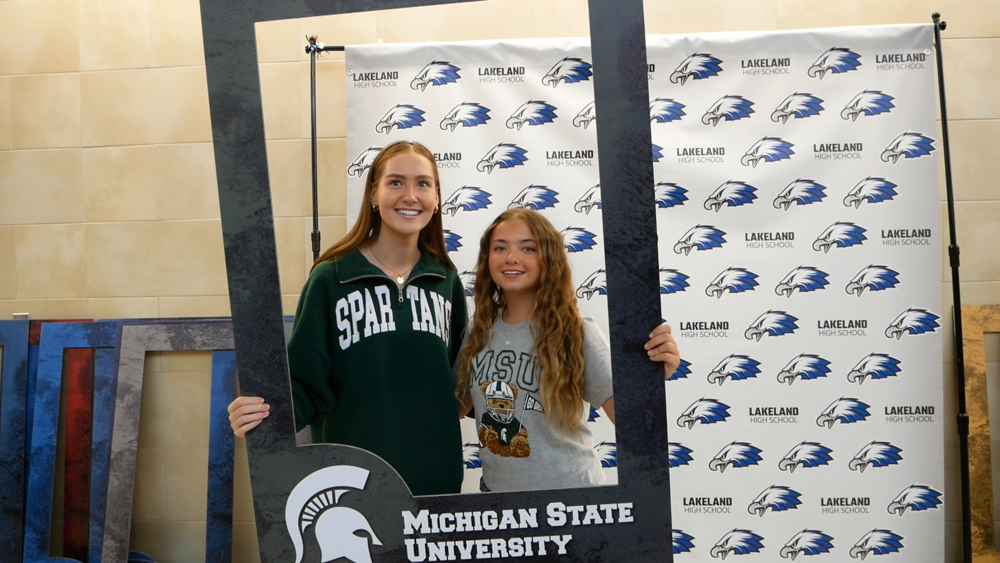 Image of two girls wearing MSU spartan shirts at decision day posing for a picture