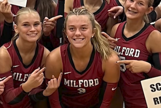 Photo os 3 girls on a volleyball team smiling ands posing for a picture in their milford uniforms