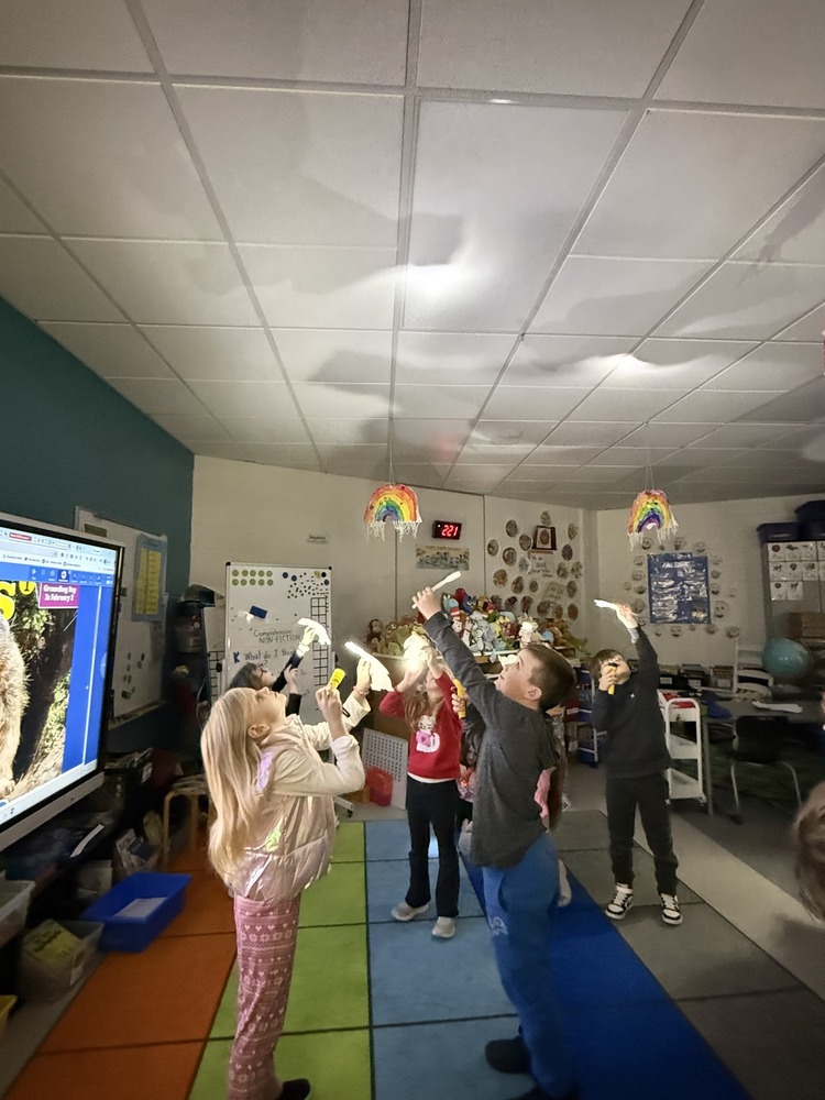 First grade students doing an activity with flashlights for Groundhogs Day