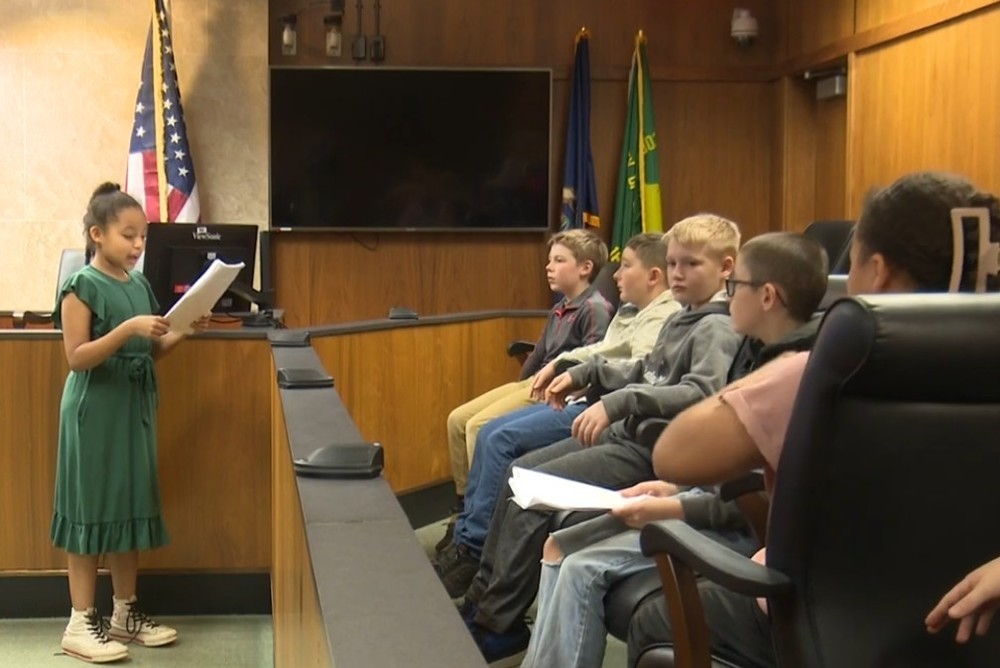 image of elemntary student in courtroom  adressing classmates in jury during mock trial