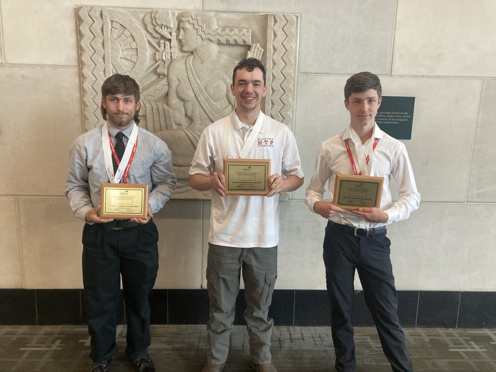 Tree students holding placques from competing in the state championships of automotive repair