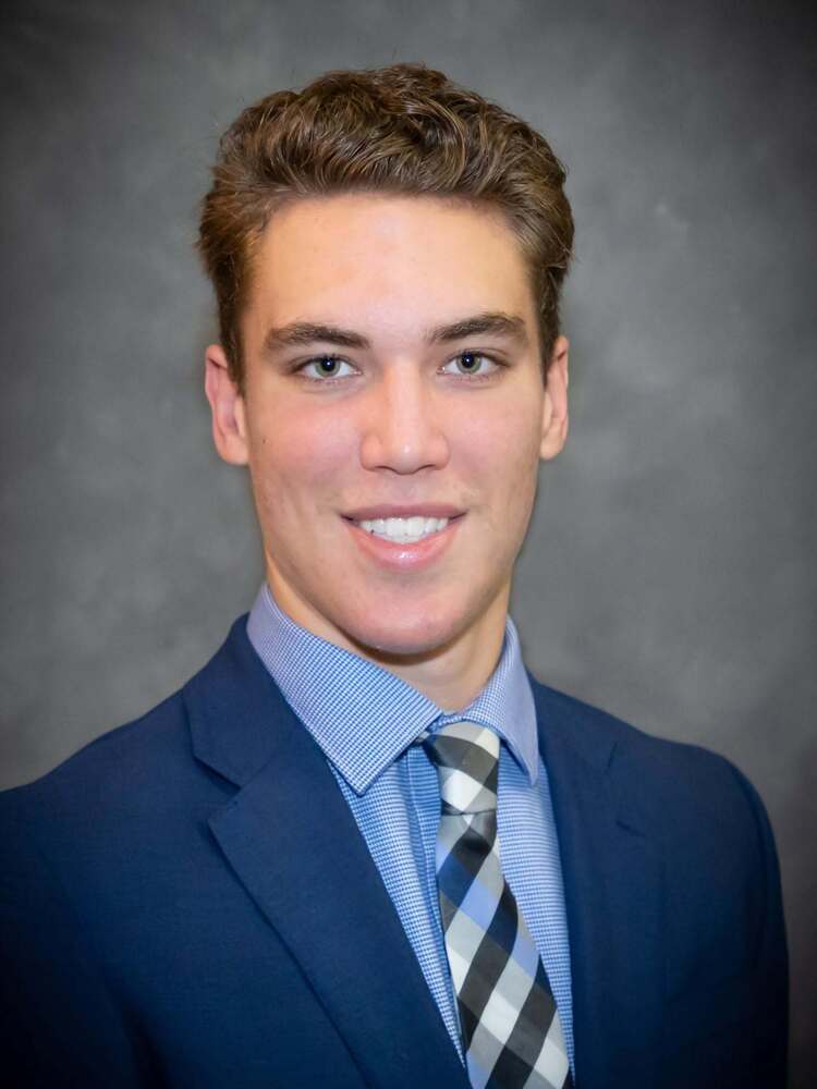 Photo of Jaden Grant, smiling in a suit