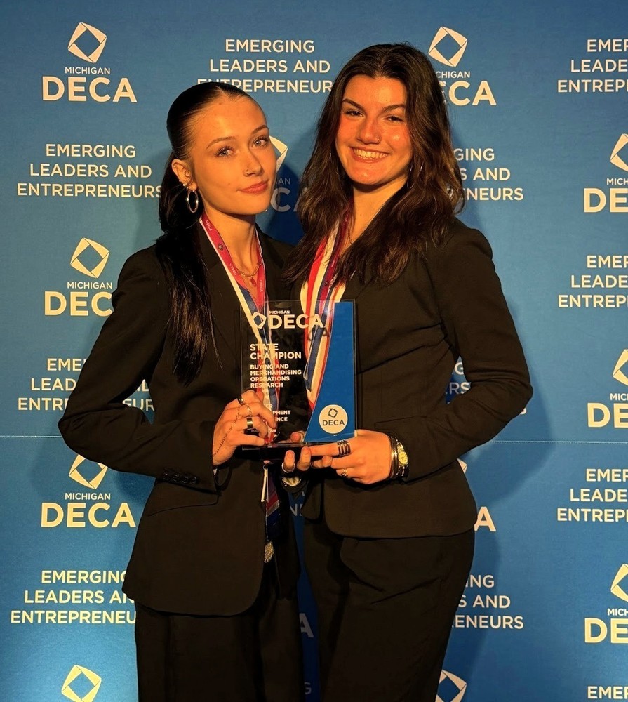 Photot of Lacey Smith & Madelynn Zumstein holding award from DECA competition