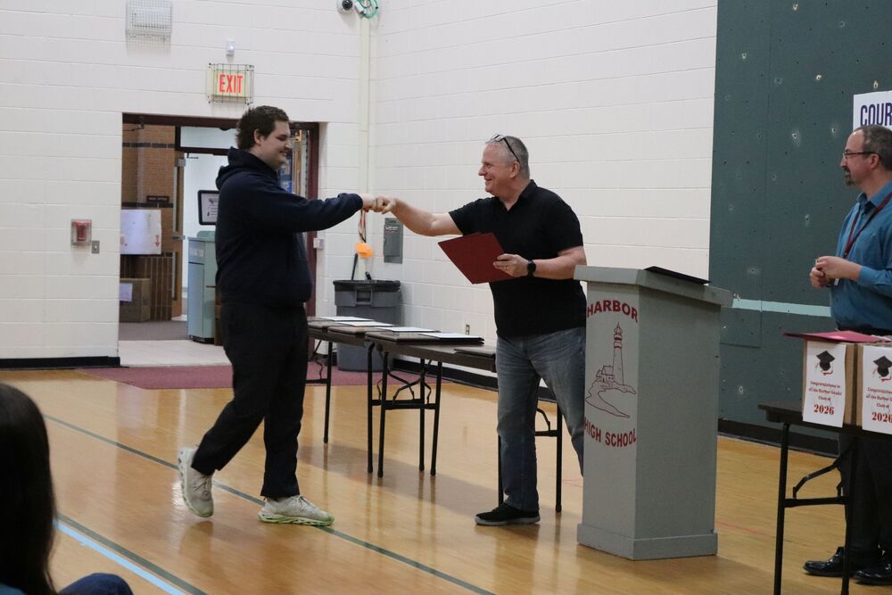 Student receives award from Mr. Pouliot at awards ceremony