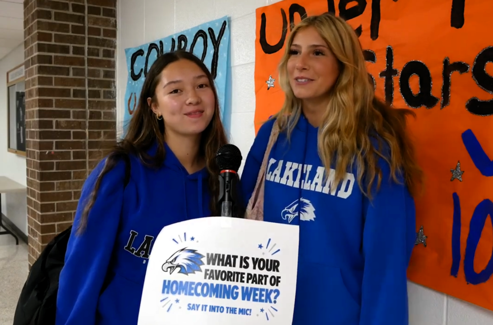 Two female students standing in front of a microphone in the school hallway