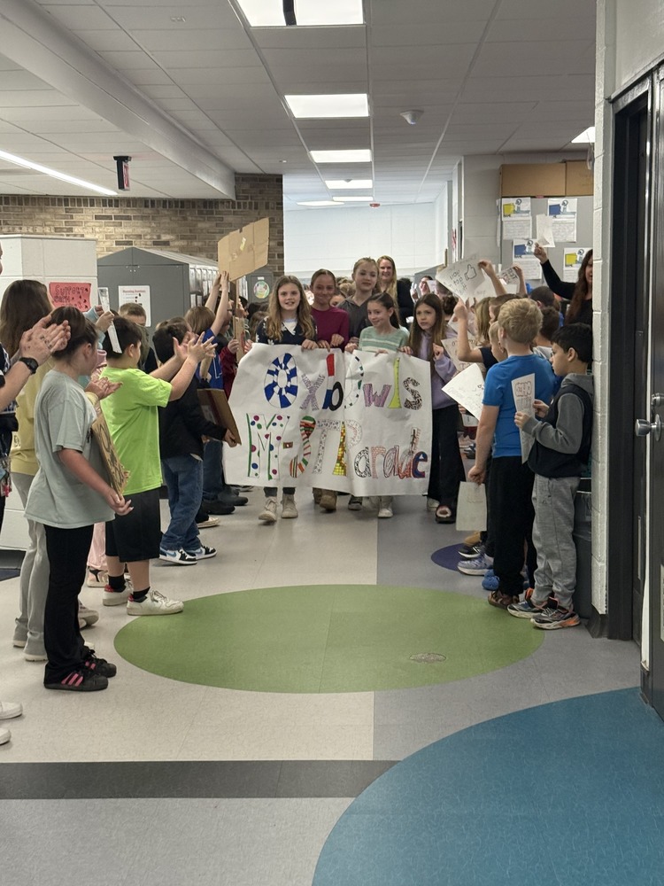 Students walking through the halls for the MStep parade with other students cheering them on