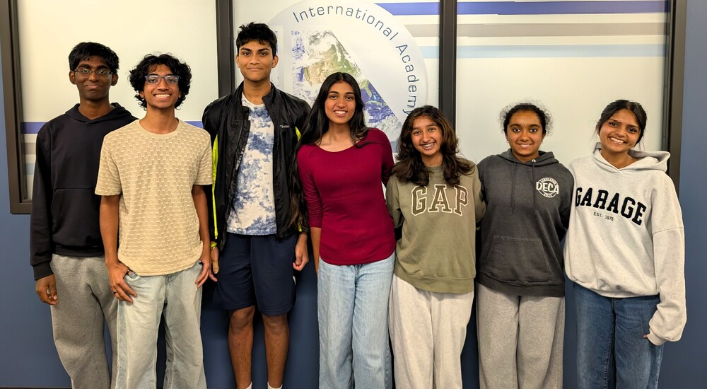 Photo of 7 students standing & posing for a group photo