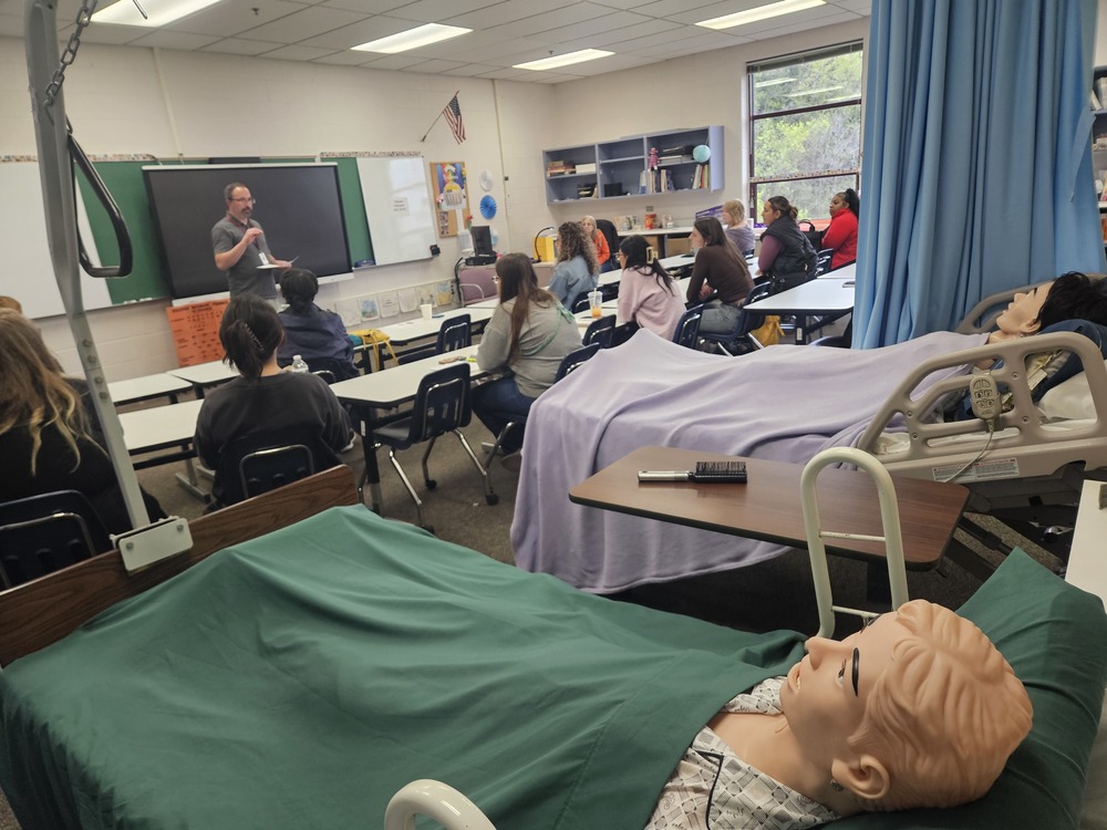 New cns students in a room listening to a speaker