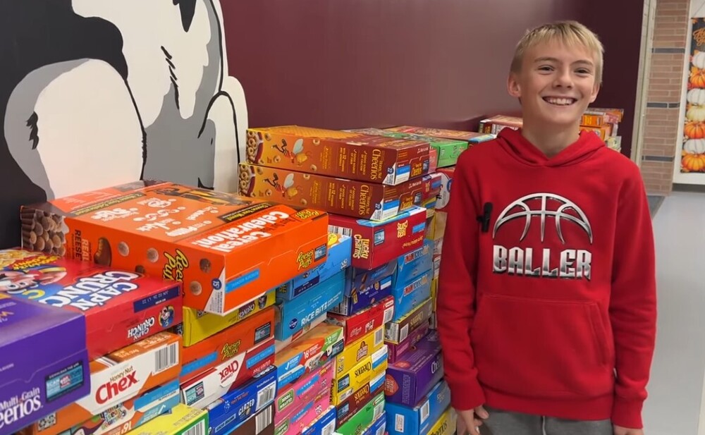 student stnading in front of wall of cereal boxes