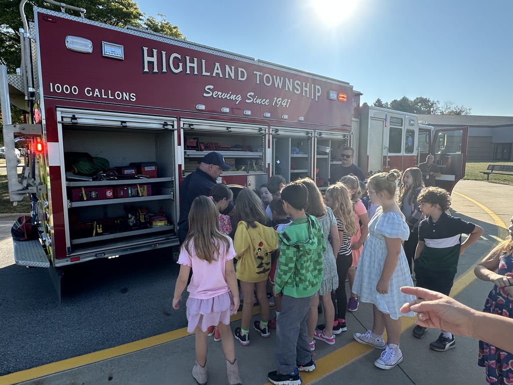 Students are looking at tools that are on a firetruck