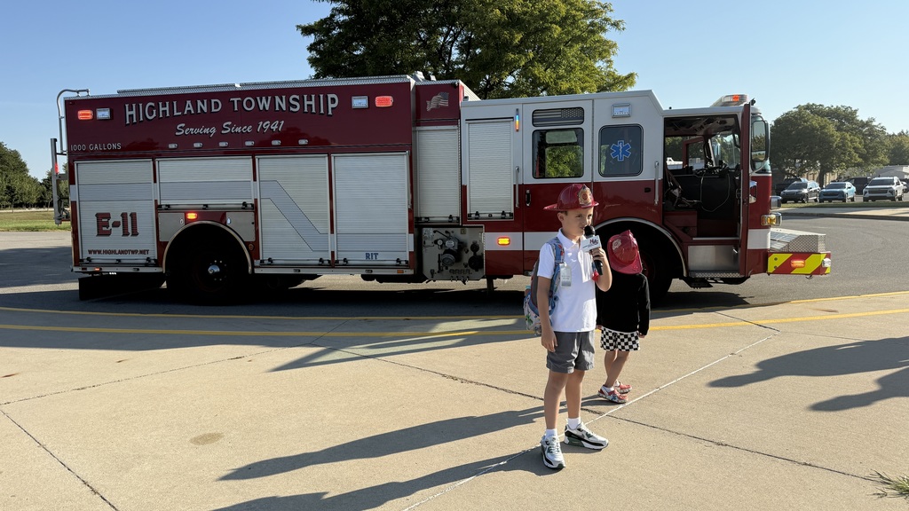 Student Winner of ride to school in a firetruck posing in front of truck