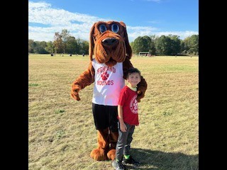 Hunter the Hound with a student at the Fun Run